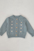 Blue children's sweater with floral patterns on a light gray background