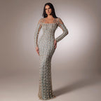 Woman wearing a long, elegant dress with intricate detailing against a neutral background