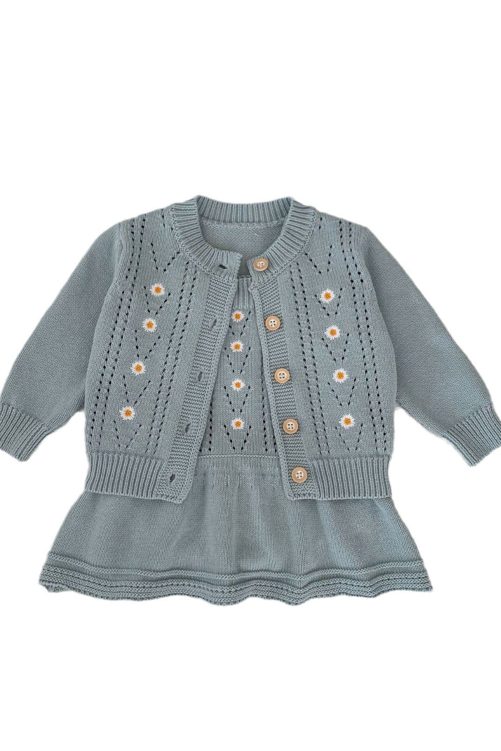 Light blue knitted dress with button details on a white background