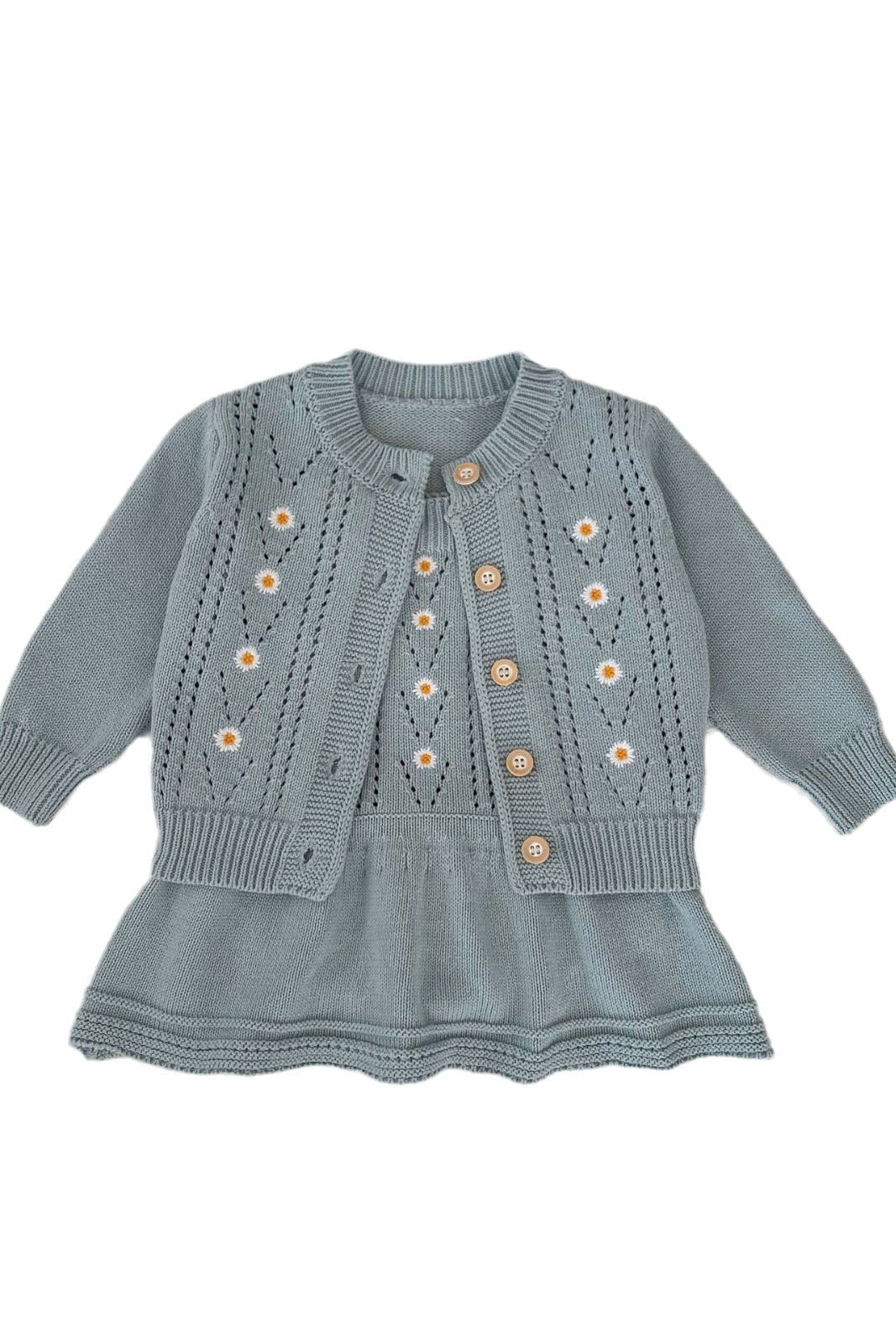 Light blue knitted dress with button details on a white background