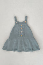 Blue knitted dress with button details on a light gray background