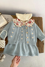 Light blue knitted dress with floral collar on a wooden surface